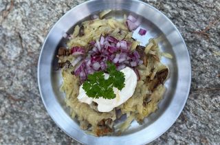 Råraka gjord på potatis och trattkantareller, serveras med rödlök och créme fraiche