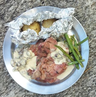 Grillad vildsvinskarré med trattkantarellsås, picklade rönnbär, frästa gröna bönor och bakad potatis