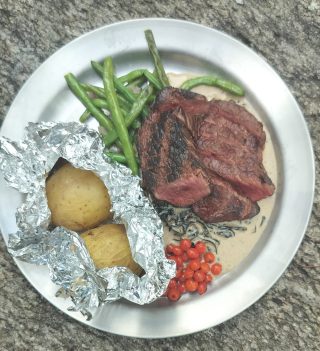 Grillad kronhjortsmedaljong, trattkantarellsås, frästa gröna bönor, picklade rönnbär och  ramslöksbakad potatis